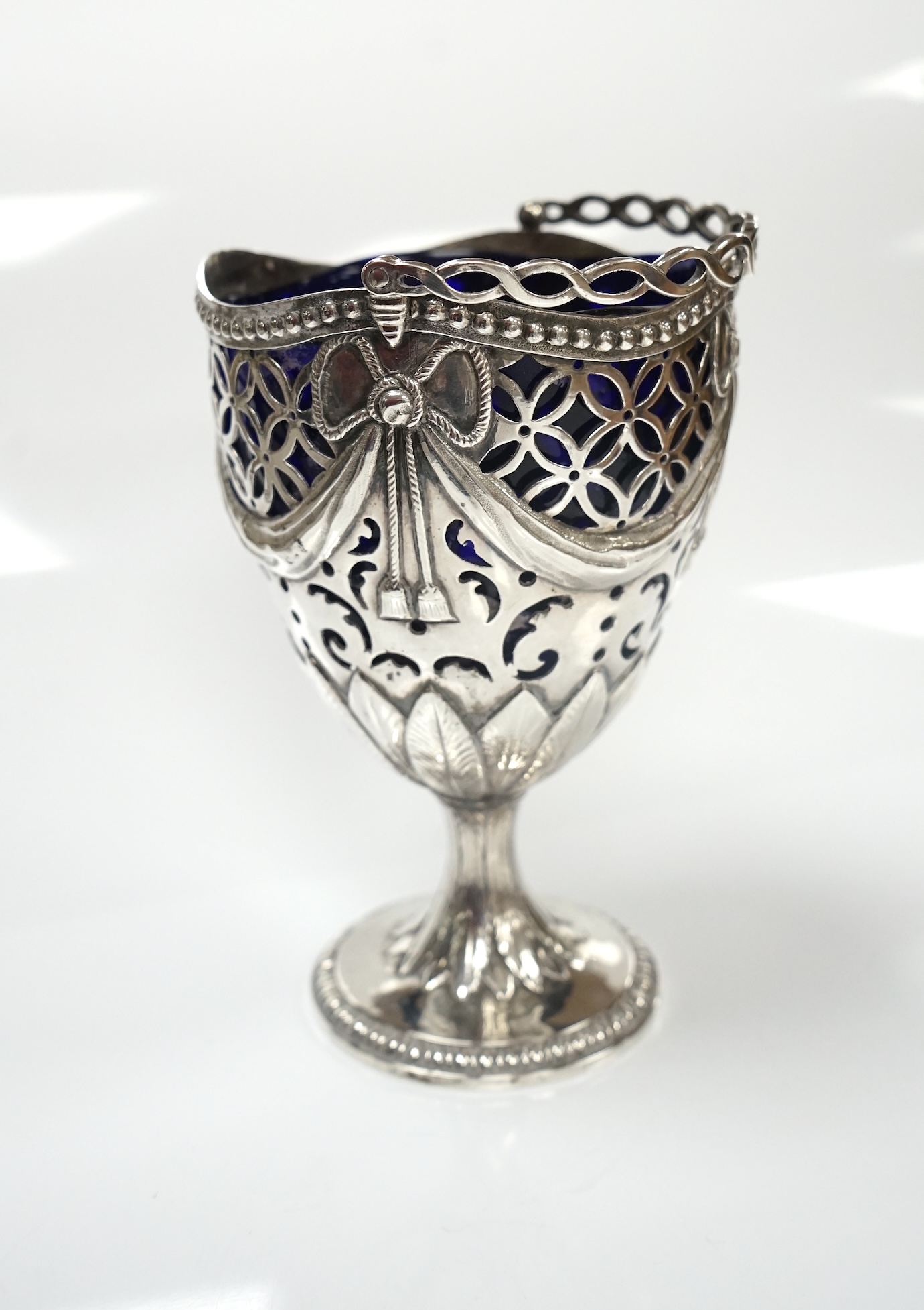 A George III silver pedestal sugar basket, with blue glass liner, indistinct marks, height 12.4cm. Condition - fair